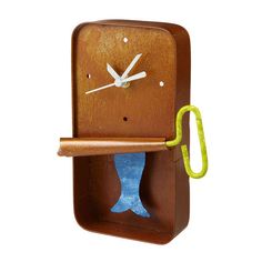 a wooden clock with a green handle attached to it's side and a blue object in the middle