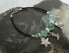 "Turquoise Charm Bracelet This beautiful charm bracelet has turquoise beads, pewter silver accent beads, velvet cord and pewter silver charms. 8\" long can be adjusted to 9\". Spring clasp." Southwestern Jewelry Kitchen, Cowgirl Bracelets, Jewelry Country, Western Bracelets, Western Necklaces, Turquoise Charm, New Plymouth, Witch Jewelry, Pagan Jewelry