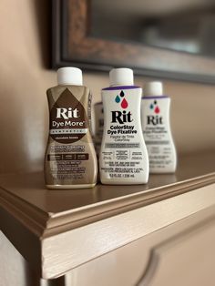 three different types of hand sanitizers on a shelf in front of a mirror