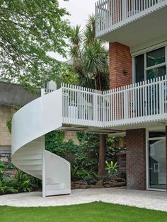 a white spiral staircase in front of a brick building