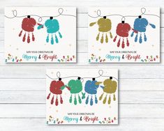 three christmas cards with handprinted hands hanging from clothes pins and stars on them