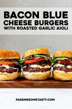 bacon blue cheese burgers with roasted garlic aioli on a cutting board next to a bottle of beer