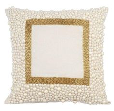 a white and gold pillow with pearls on it