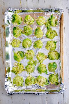 broccoli florets are placed on aluminum foil and ready to be cooked