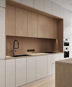 a modern kitchen with white cabinets and wood counter tops, an island style sink and stainless steel faucet