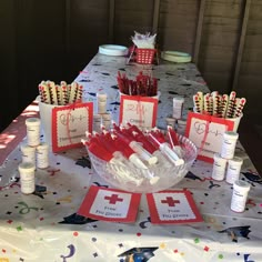 the table is set up with red and white items for an emergency themed birthday party