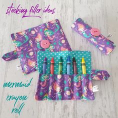 the mermaid crayon roll is made from fabric and has four markers in it