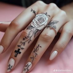 a woman's hand with tattoos and a cross on it