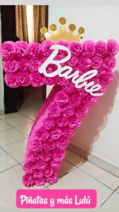 a pink balloon shaped like the letter e with a crown on top that says barbie