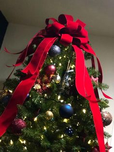 a christmas tree with red ribbon and ornaments