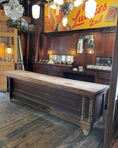 a large wooden table sitting in the middle of a room with lights hanging from it