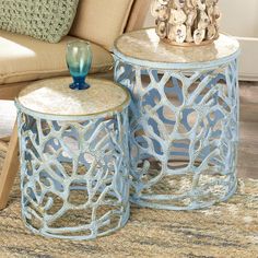 two blue tables sitting on top of a rug in front of a couch and chair