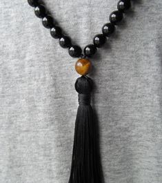 "Gorgeous traditional 108 bead mala made with authentic and high quality black onyx and tiger eye for the guru bead and spacers. The mala is finished with a hand tied black silk tassel, or optional no tassel. Mala measures 36\" around. Materials: 8mm black onyx beads 8mm tiger eye beads 10mm tiger eye bead Black knotting thread Black hand tied cotton tassel (optional) * All jewelry is handmade by me with care in my home studio using the finest gems and highest quality materials. * I pride myself Handmade Black Mala For Meditation, Black Gemstone Beads Mala For Healing, Black Bohemian Mala With Gemstone Beads, Black Bohemian Mala With Round Beads, Bohemian Black Mala With Round Beads, Bohemian Black Mala For Healing, Black Spiritual Mala For Healing, Black 108 Beads Mala For Meditation, Black Mala With 108 Beads For Meditation