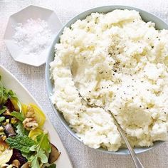 a plate of mashed potatoes and vegetables next to a bowl of salad