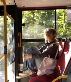 a woman sitting on a bus looking out the window