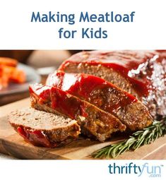 meatloaf with ketchup on a cutting board and carrots in the background