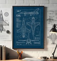 a blueprinted airplane is hanging on the wall next to a desk with a lamp