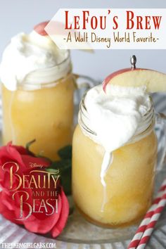 two mason jars with whipped cream and an apple slice on top, sitting next to each other