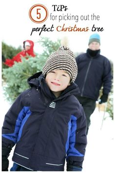 a young boy standing next to an older man in the snow