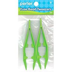 two green plastic toothbrushes sitting on top of each other in front of a package