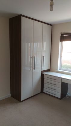 an empty room with white and brown furniture