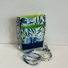 "Cross body phone bag in pretty flowery blues/greens by designer Moda fabrics. This is the perfect hands-free phone bag, for people on the go! Spacious interior (fits an iPhone 13Plus) with an extra outer zipper pouch to store your keys, money, or cards. The adjustable strap allows you to decide how close to your body you wish to wear it.  Great for when you need something simple to keep your items, while out walking the dog, taking your kids to school/events, travelling, rushing off to the gym Blue Phone Bag With Cell Phone Pocket For On-the-go, Green Pouch Phone Bag For Travel, Green Travel Pouch Phone Bag, Green Phone Bag With Removable Pouch For Travel, Green Crossbody Phone Bag With Cell Phone Pocket, Green Phone Bag With Cell Phone Pocket For On-the-go, Perfect Hands, Crossbody Phone Bag, Walking The Dog