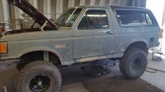 an old pick up truck is parked in a garage