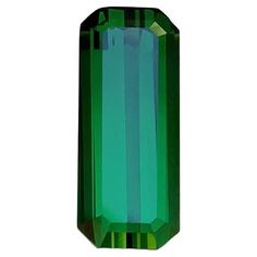 an emerald colored stone with green stripes on the outside and inside, against a white background