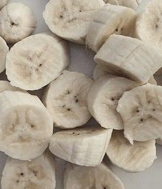 sliced bananas are arranged on a white surface