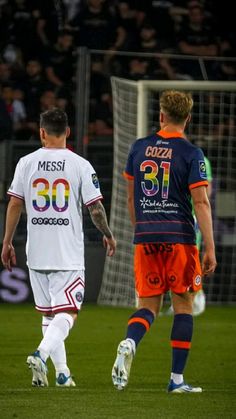 two soccer players are walking on the field