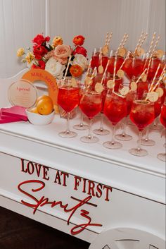 a table topped with lots of glasses filled with liquid and strawberries on top of it