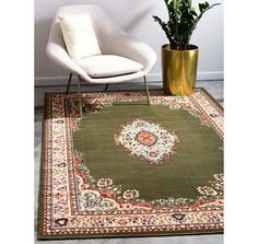 a green rug with an ornate design in the middle and a white chair next to it