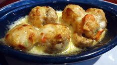 a blue bowl filled with meatballs covered in gravy on top of a table