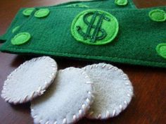 two green and white felt pieces sitting on top of a wooden table