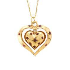 "This charming 14k yellow gold and Ruby pendant features two articulating hearts, both fashioned into a dome with a solid flat back. The inside heart is bead set with eight round Rubies; the inside heart dangles inside the center of the larger open heart, which has six bead-set, round Rubies. Perfect sentimental gift for your heart throb!   -  14k yellow gold  -  Outer Heart (frame): 1.13\" x 1.03\" x .17\" (28.80 wide x 26.30 long x 4.50mm deep) -  Inside Heart: .70\" x .63\" x .23\" (18.00 wide x 16.00 long x 5.80mm deep) -  Rubies: 14/0.03 to 0.06ct each, 0.62ctw (estimated due to mounting) -  Ruby color: Medium dark, very slightly brownish, slightly purplish red (slpR 6/3).  -  18\" Box Chain: 14k yellow gold (stamped), spring ring closure, .90mm wide  -  Total Weight: 10.34 grams comp Yellow Gold Heirloom Jewelry With Heart Charm, Heirloom Yellow Gold Jewelry With Heart Charm, Heirloom Heart-shaped Yellow Gold Jewelry, Heirloom 14k Gold Heart Jewelry, Heirloom Yellow Gold Jewelry For Valentine's Day, Antique Heart-shaped 14k Gold Necklace, Antique Yellow Gold Necklaces For Valentine's Day, Heirloom 14k Gold Stamped Heart Necklace, Heirloom Heart Necklace Stamped 14k