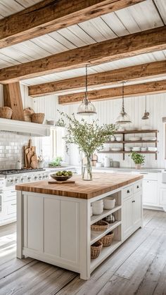 a white kitchen with wooden floors and beams on the ceiling is filled with hanging lights