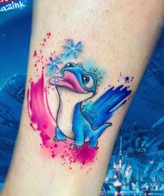 a small tattoo on the leg of a person with a blue and pink bird in it