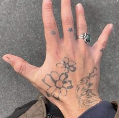 a person with tattoos on their hand and fingers