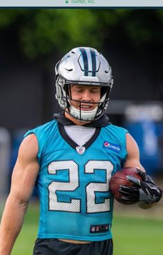 a football player holding a ball and wearing a helmet with the number 22 on it