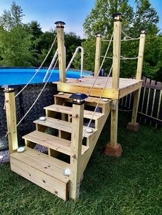 a wooden deck with steps leading up to a swimming pool