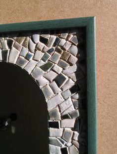 a door with a small mosaic design in the middle and a mirror on the outside