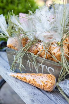 a wooden bench topped with lots of food next to a bag filled with rice krispy kreme