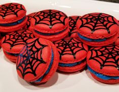 red and black spiderman macaroons on a white plate