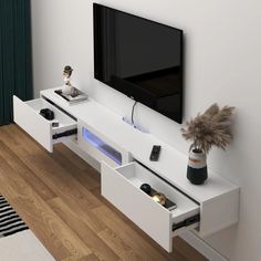 a flat screen tv sitting on top of a white entertainment center next to a wooden floor