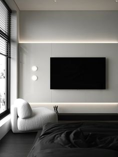 a large flat screen tv mounted to the side of a wall next to a bed