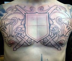 a man's chest with a tattoo on it that has a coat of arms and two swords