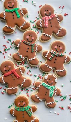 several decorated ginger cookies on a table with sprinkles