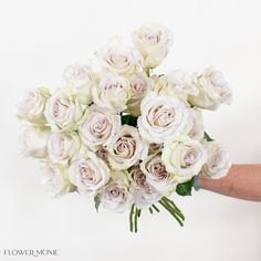 a woman holding a bouquet of white roses