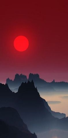 the sun is setting over some mountains in the foggy misty valley below it