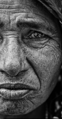 black and white photograph of an old woman's face with wrinkles on her eyes